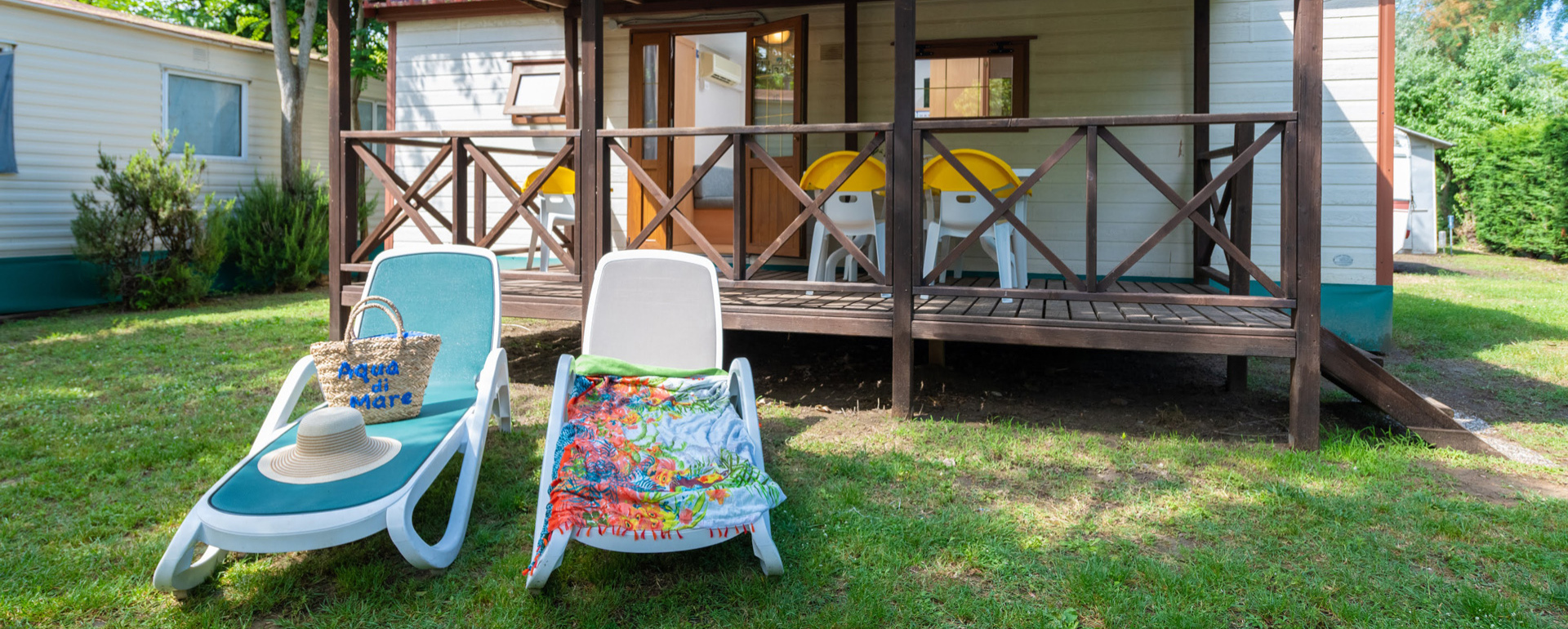 Bungalow con veranda, sdraio e giardino, ideale per una vacanza rilassante.
