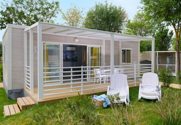 Eleganter Bungalow mit Veranda, umgeben von Grün, lädt zur Entspannung und Gelassenheit ein.