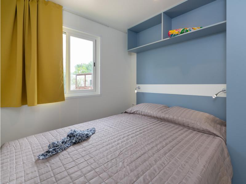 Camera accogliente con letto morbido e luce calda.