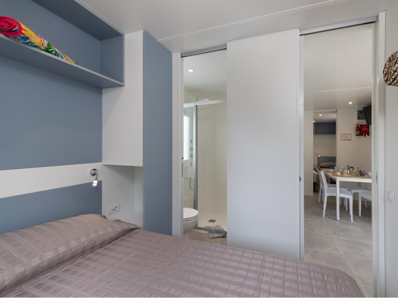 Camera moderna e luminosa con bagno e zona pranzo accogliente.