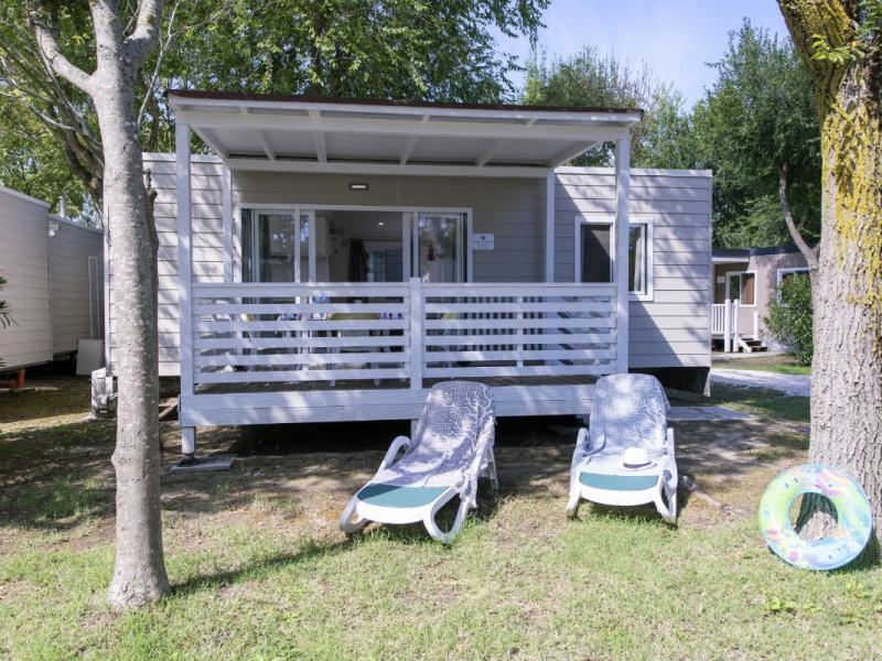 Casa mobile con veranda, sdraio e giardino.