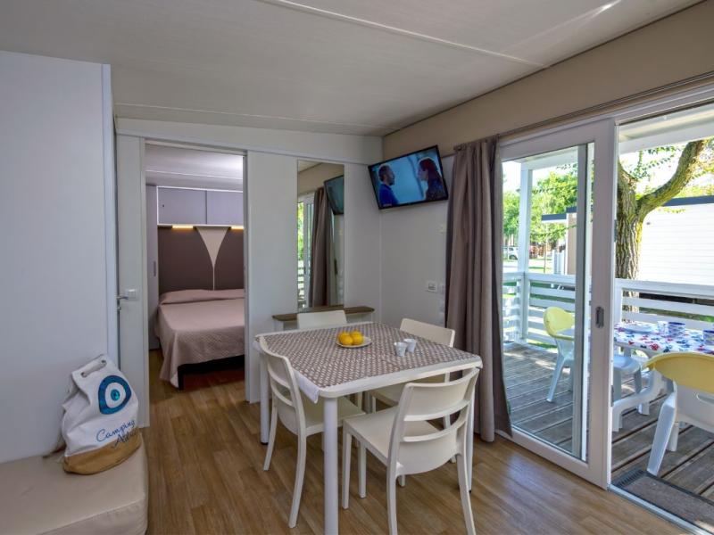 Interno moderno con tavolo e accesso al balcone.