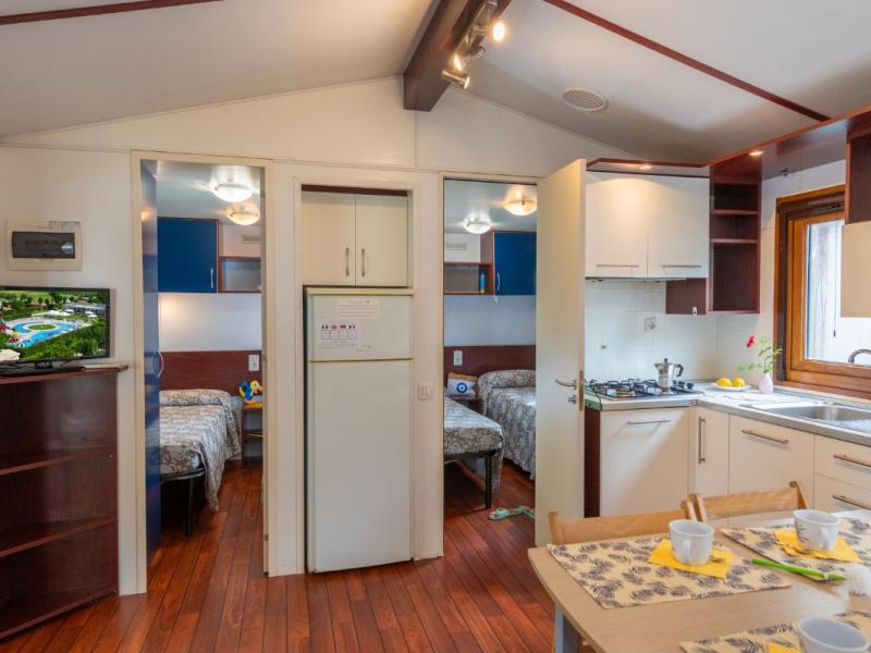 Interno di una casa con cucina e due camere da letto.