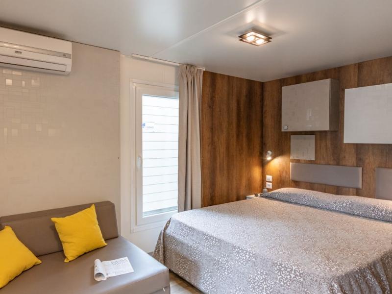 Camera moderna con letto matrimoniale e divano.